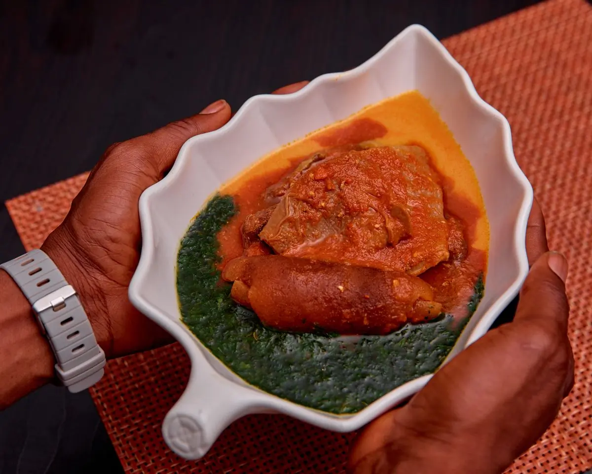 Palm nut soup with goat, in a leaf-shaped bowl