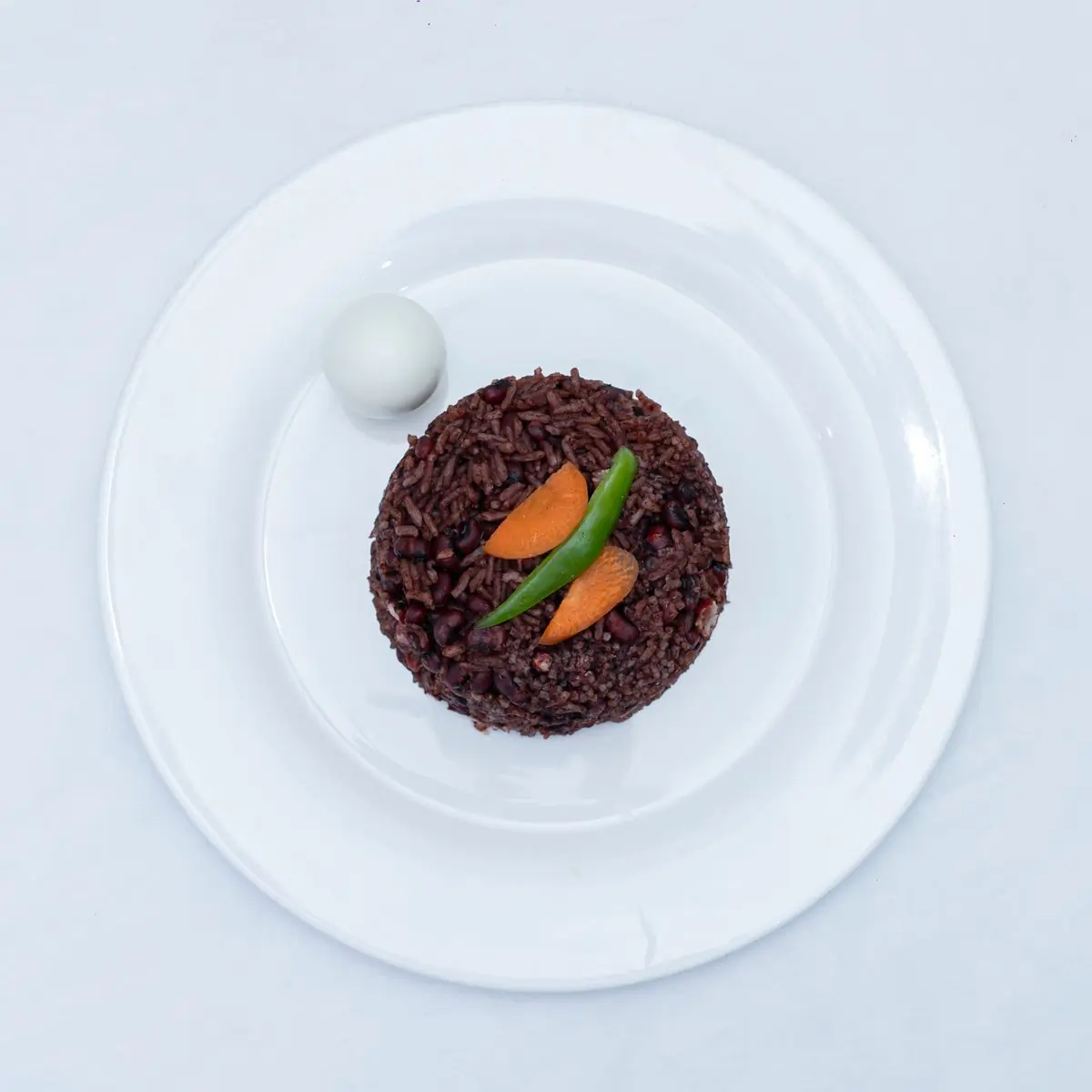 A waakye plate with shito, egg and gari