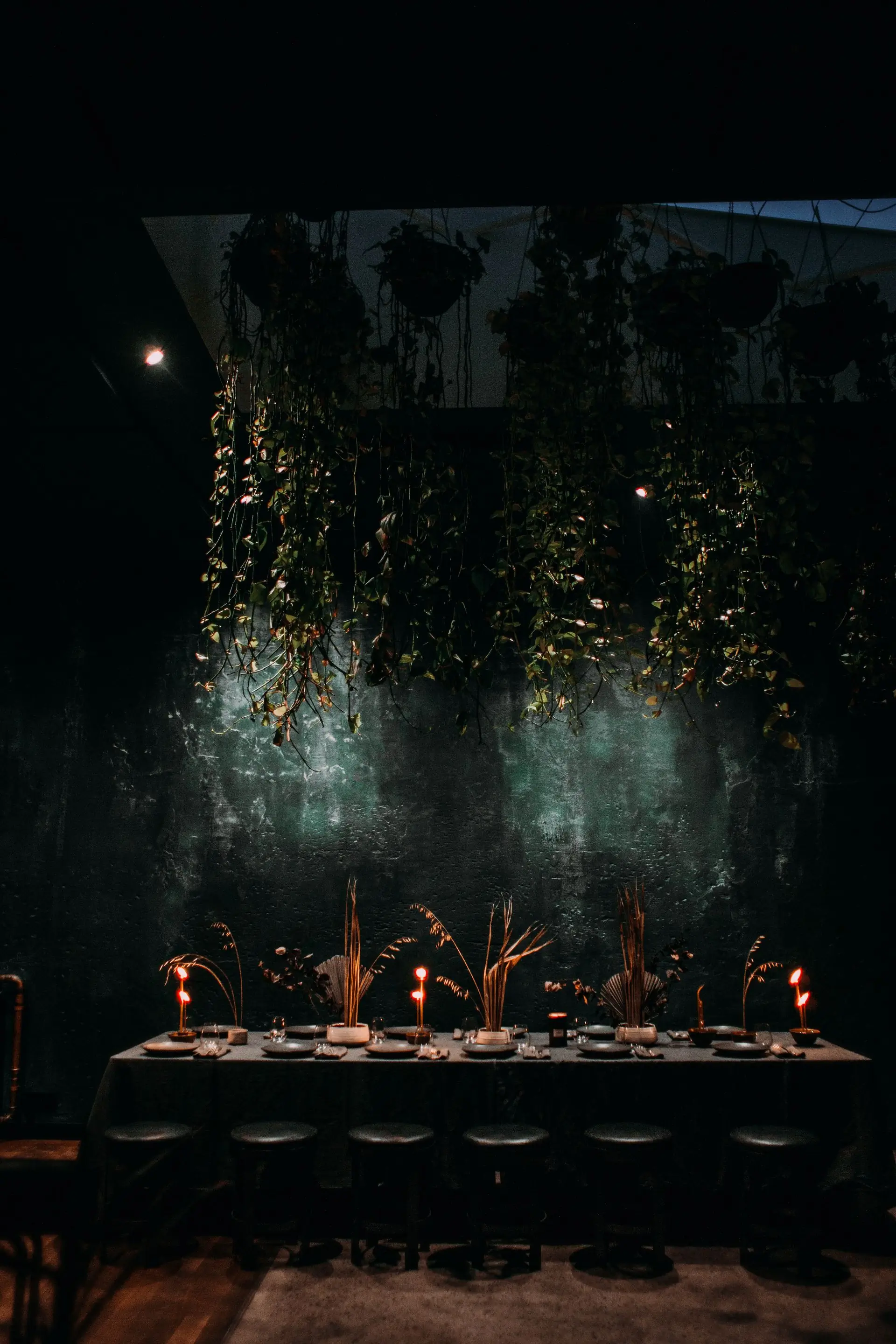 The dining room after dark, laid with candles and dried grasses