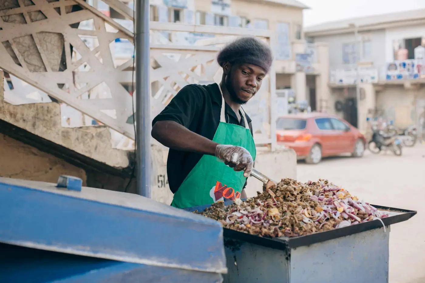 A street vendor cooking jollof over an open fire in Accra