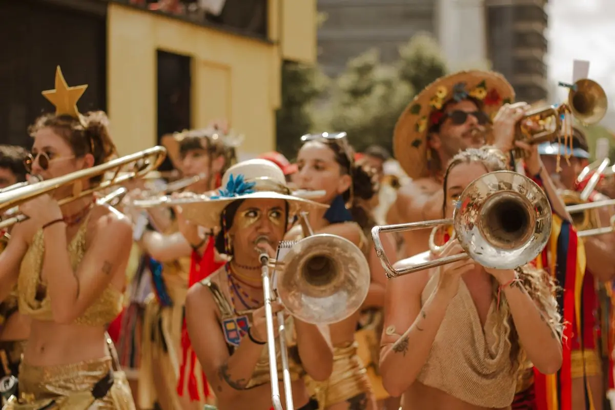 A brass band in costume playing trombones at an outdoor parade