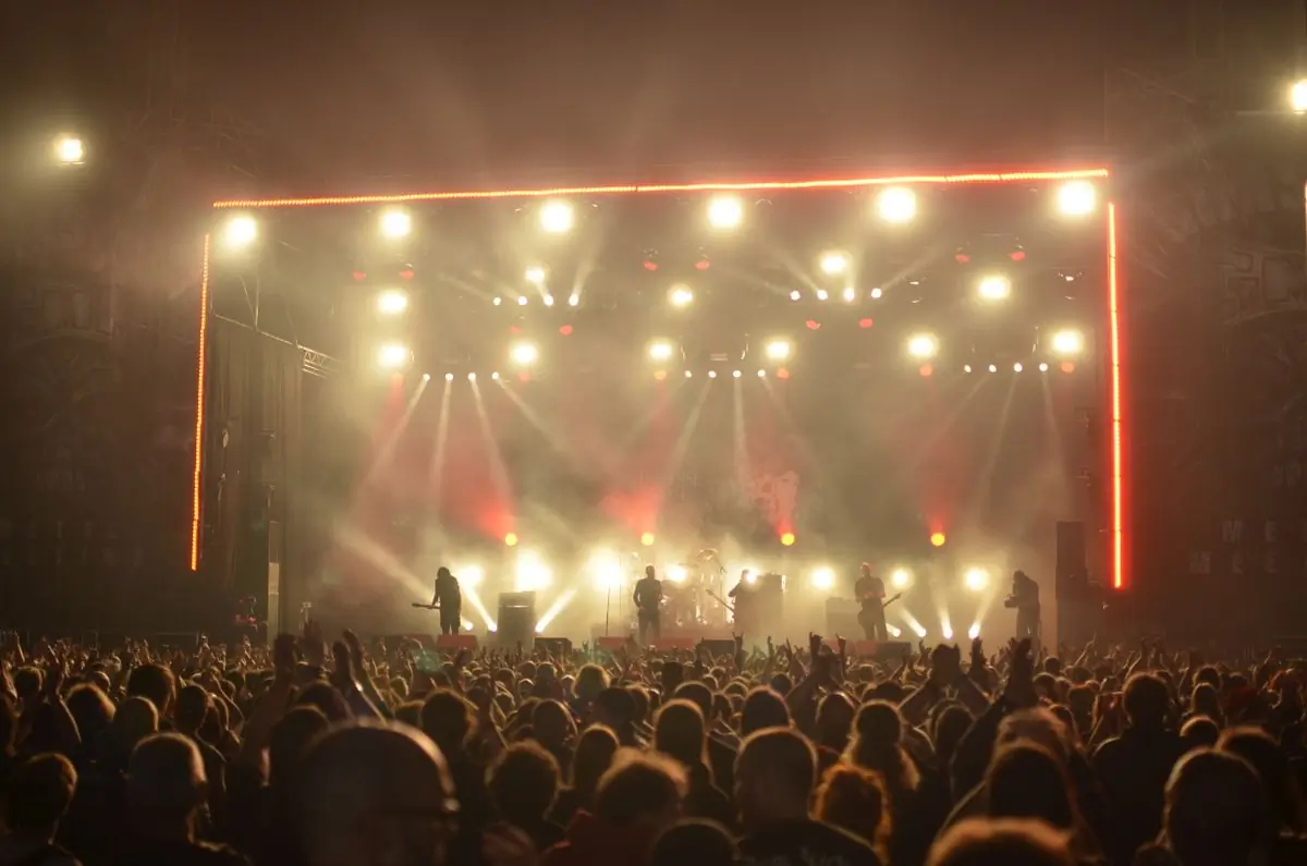 The main stage lit in warm light with the crowd filling the field