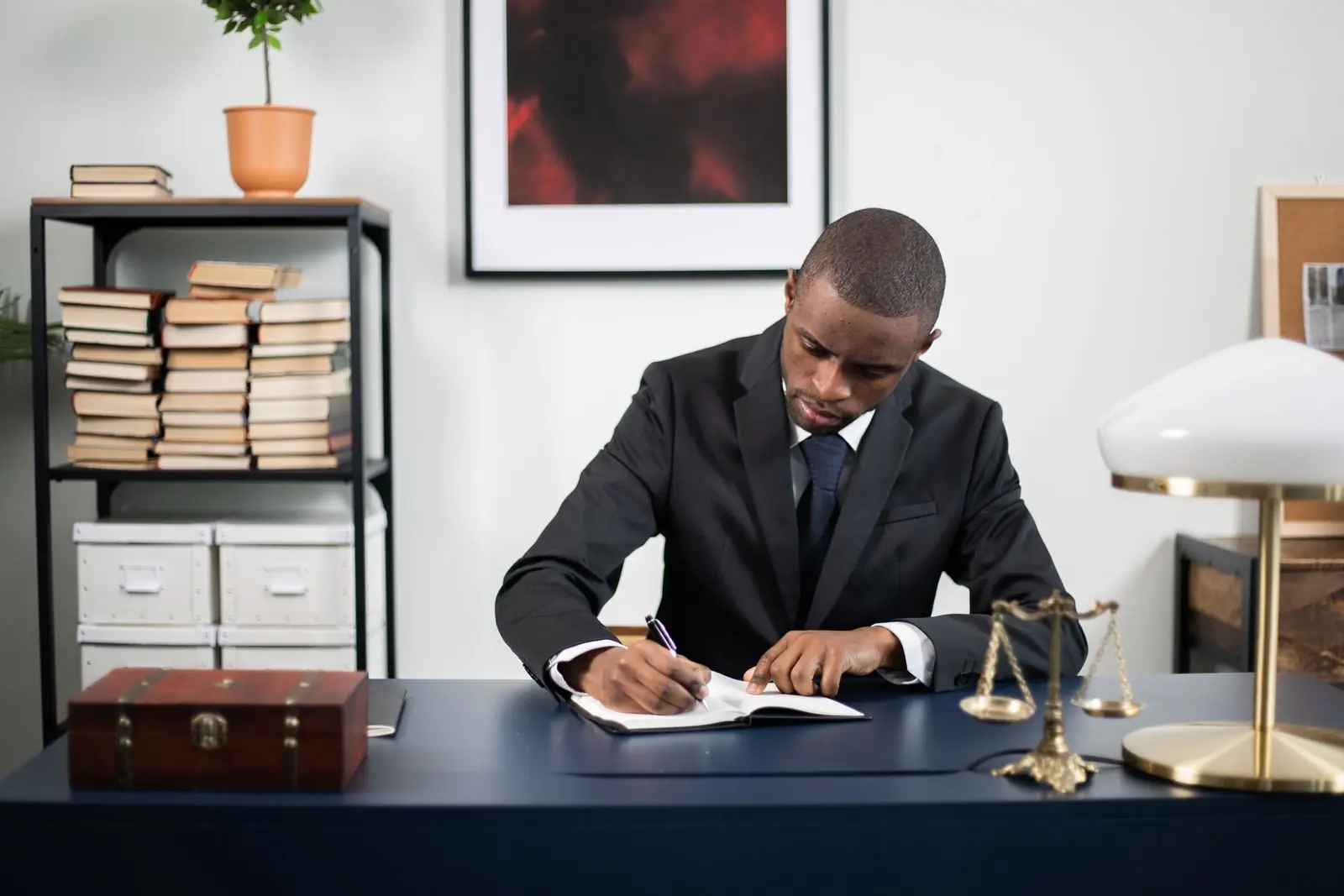 An advocate at his desk in the firm's chambers, drafting by lamplight