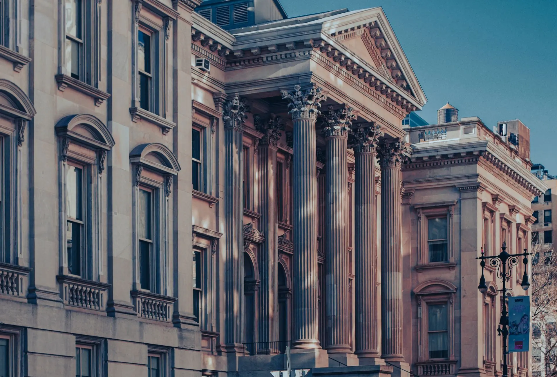 The colonnaded facade of a courthouse at dusk