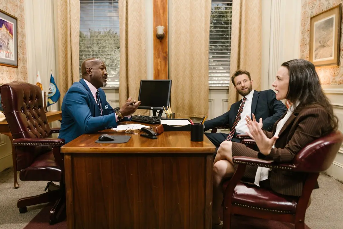 Three advocates in discussion around a boardroom table