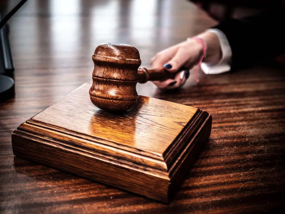 A wooden gavel resting on a judge's bench