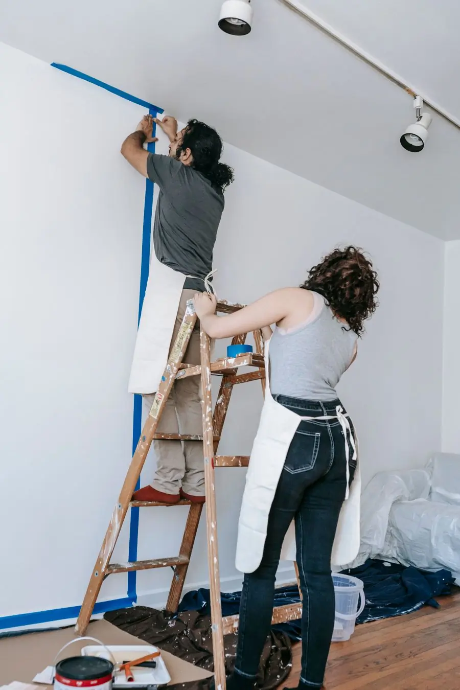 A couple preparing a bedroom wall for painting