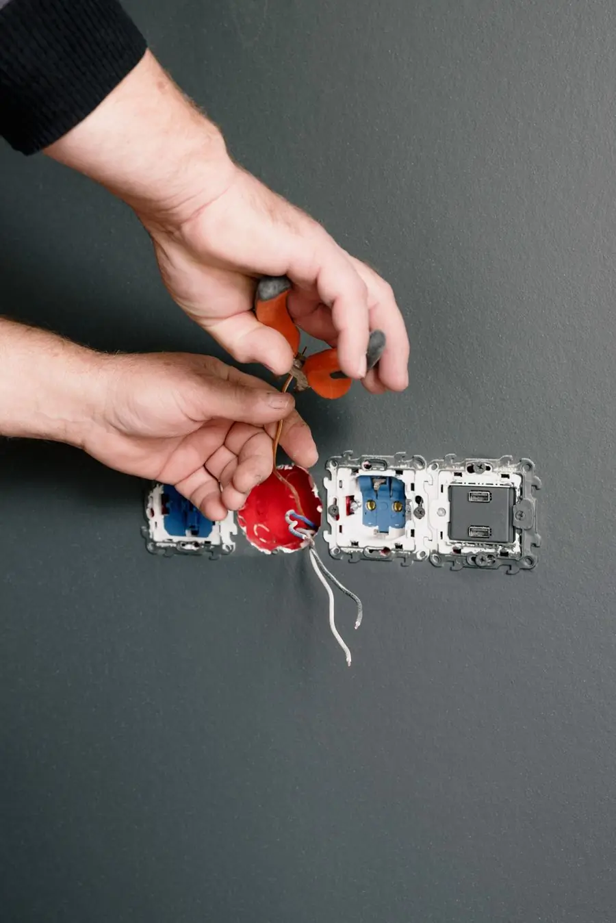 An electrician making off a run of sockets