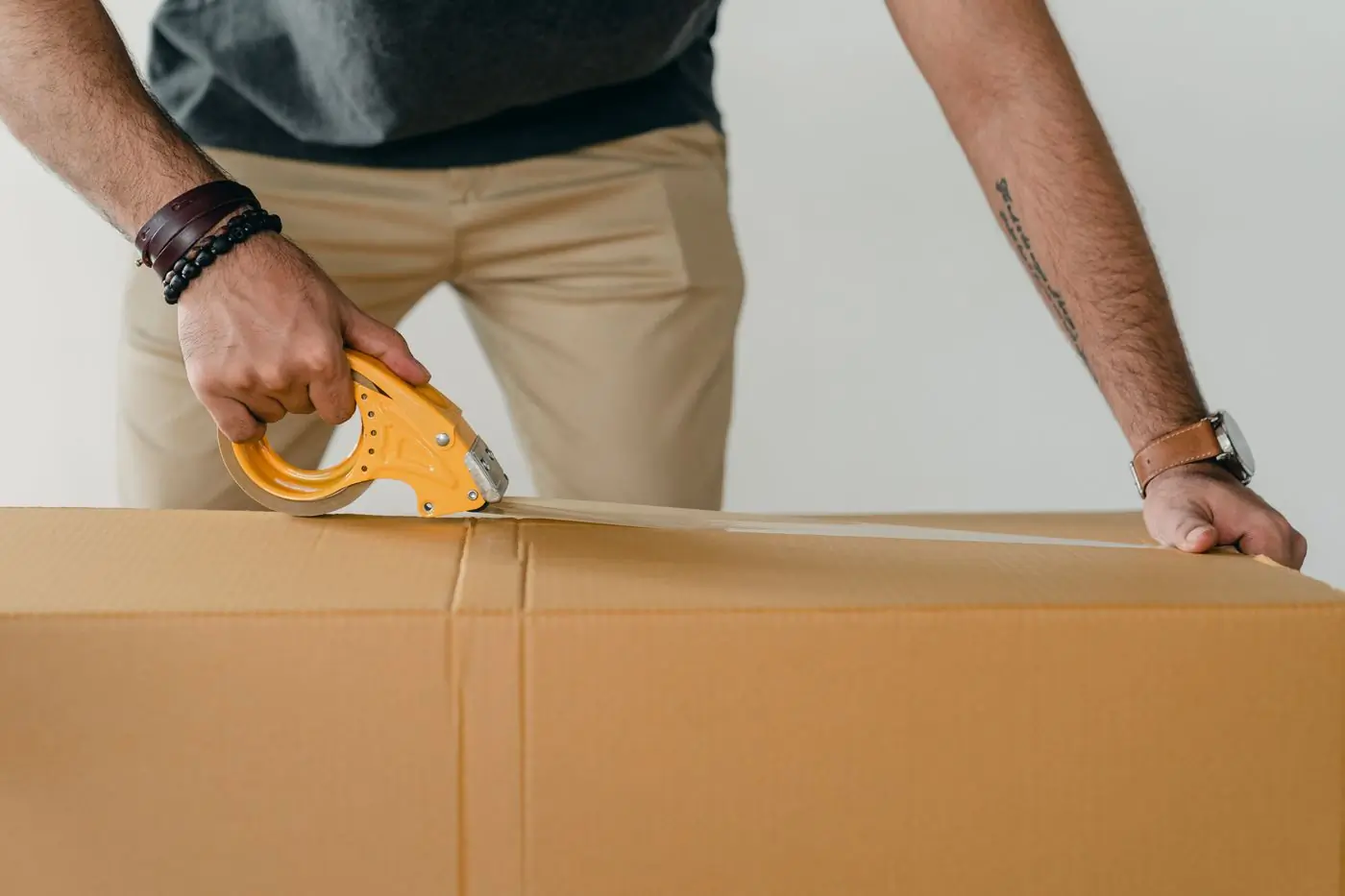 A kraft carton being taped shut, ready to leave the kitchen