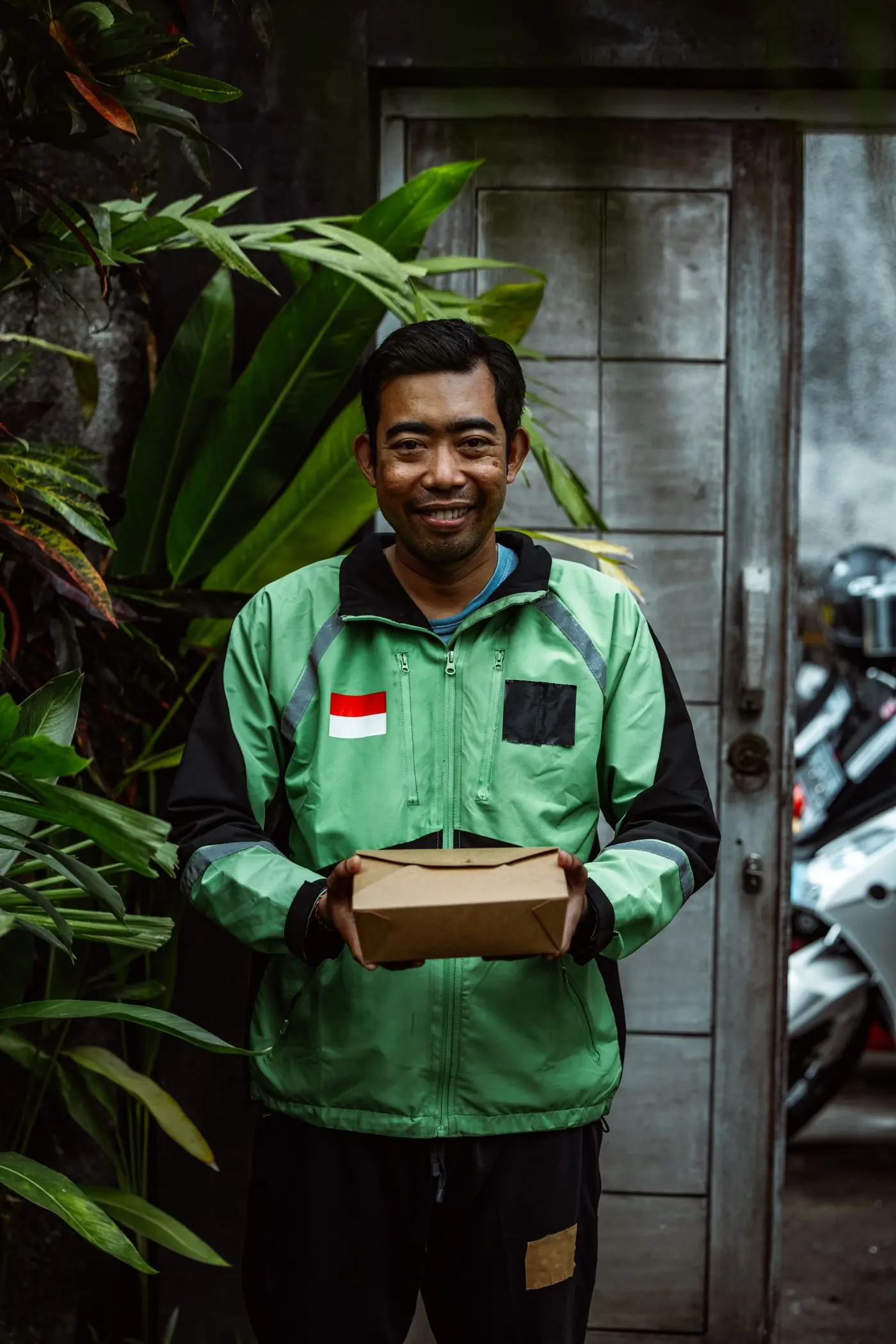A courier holding a plain kraft box of Crunch, ready to go out