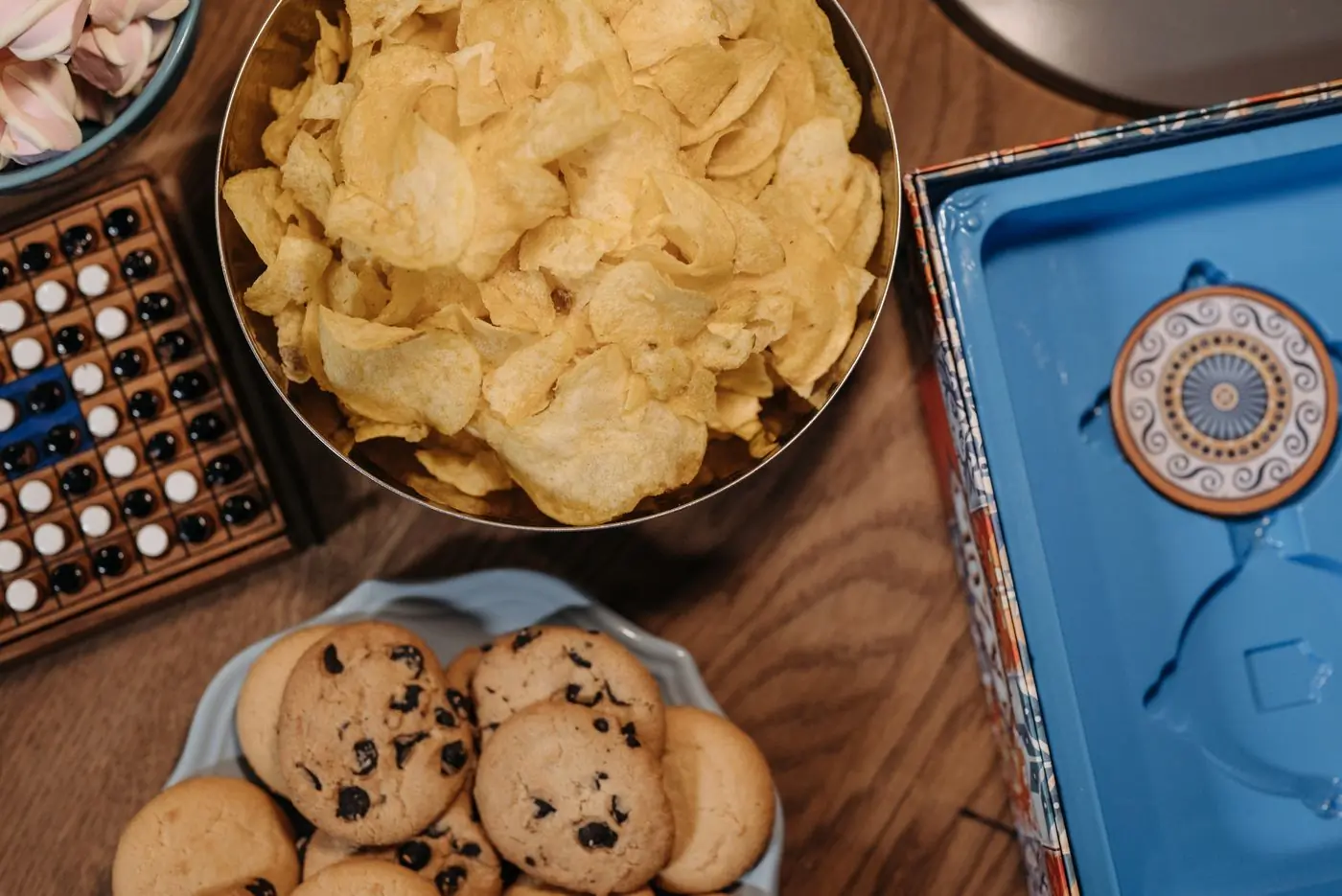 Game night from above, a bowl of chips beside the board