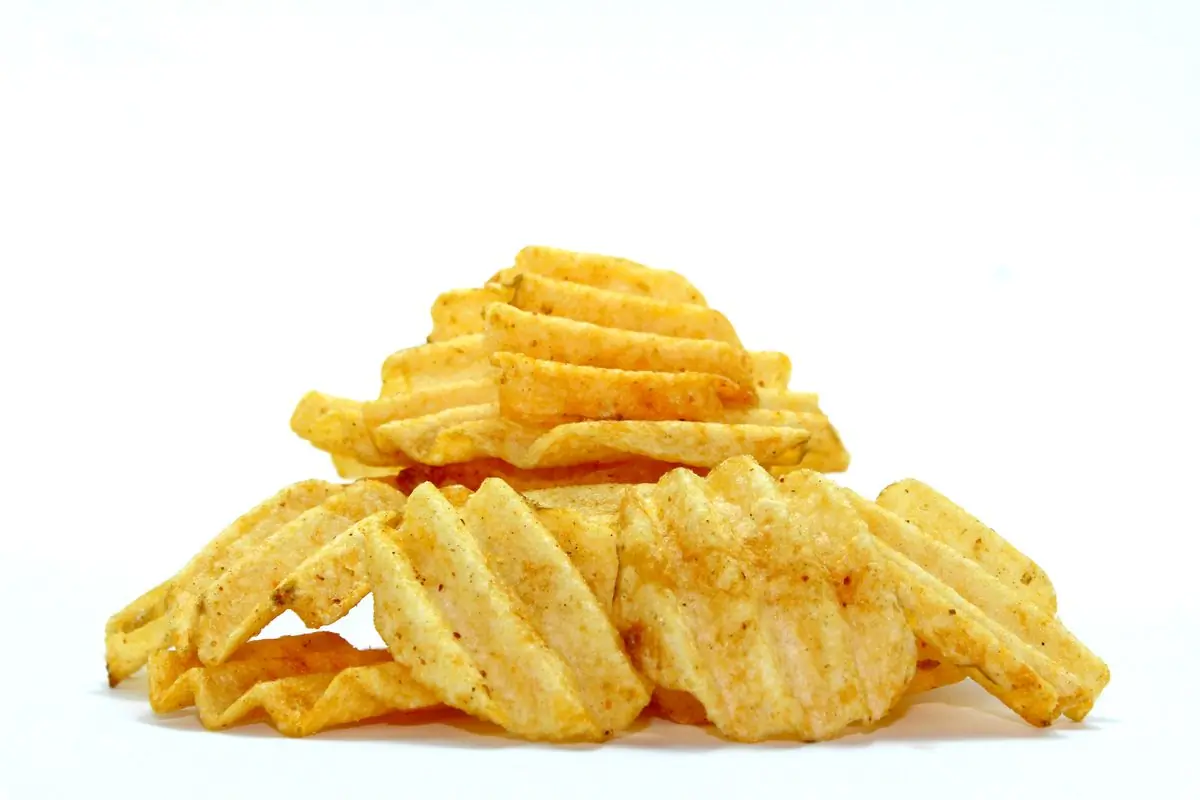 A neat stack of wavy seasoned chips on a clean white ground