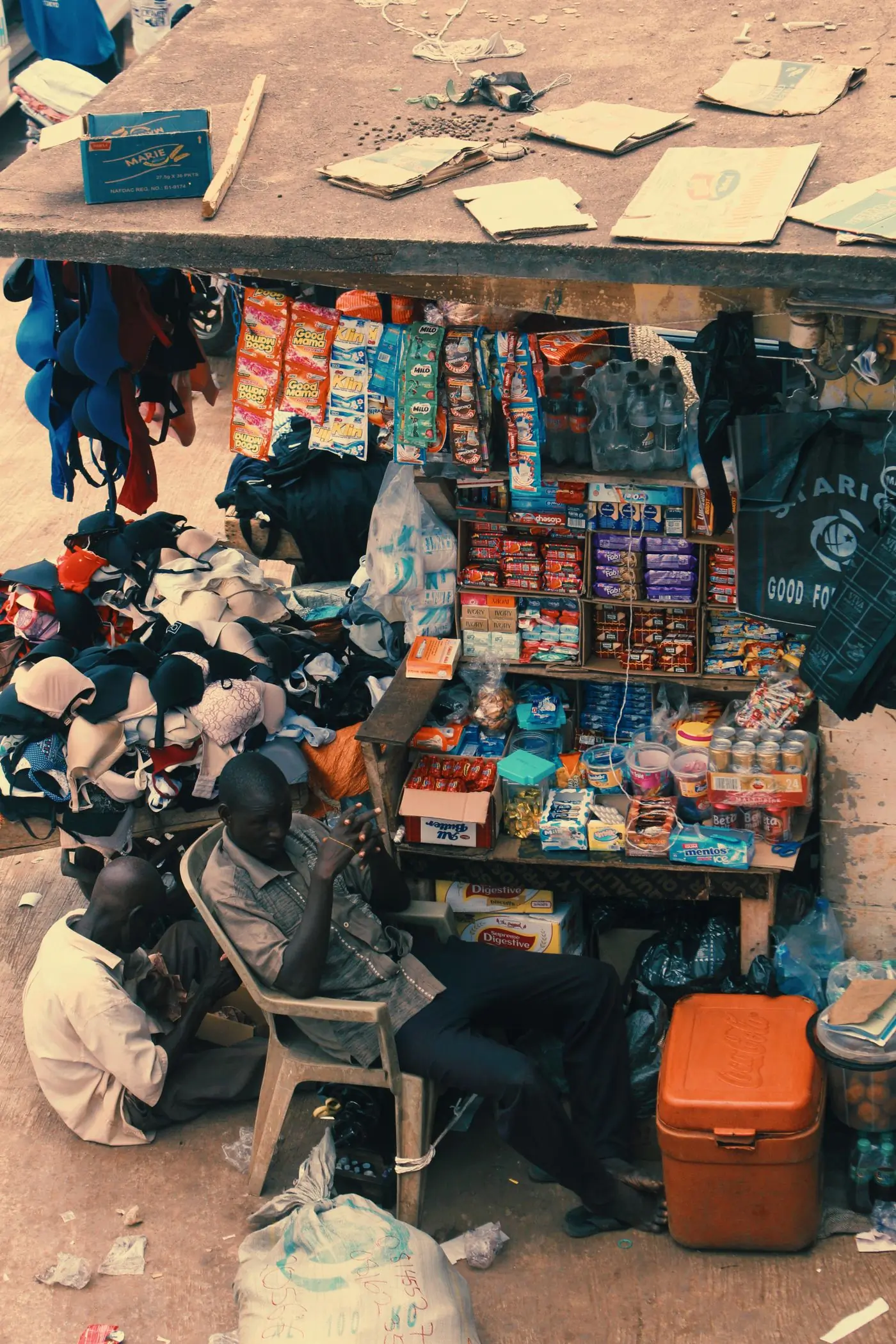 A street kiosk seen from above, an orange cooler standing out front