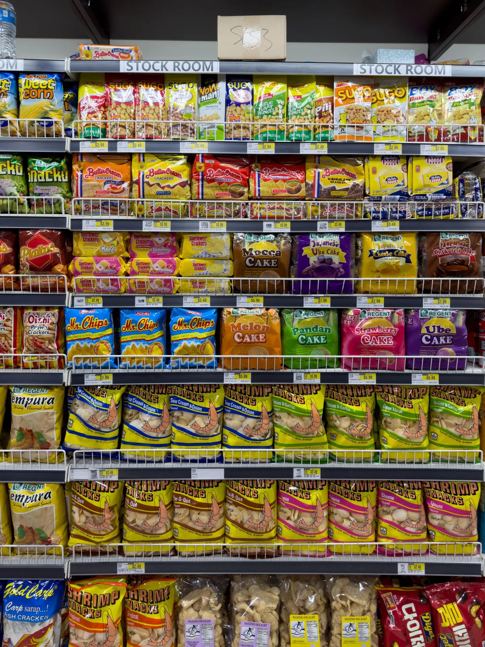 A floor to ceiling shop wall stacked with colourful bags of snacks