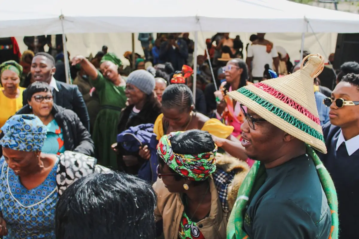 A joyful crowd in bright cloth dancing together at an outdoor gathering