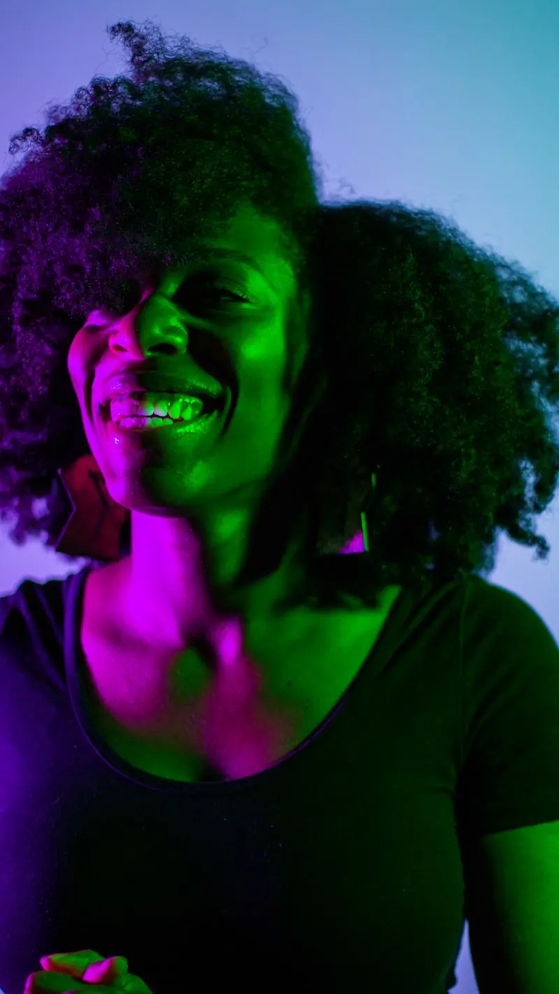 A singer photographed under magenta and green stage light