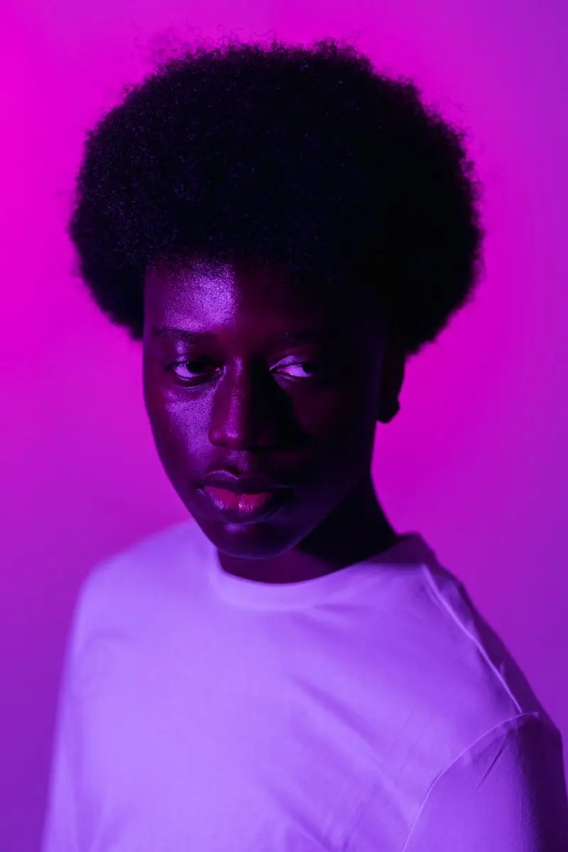 A partner photographed against a deep magenta ground