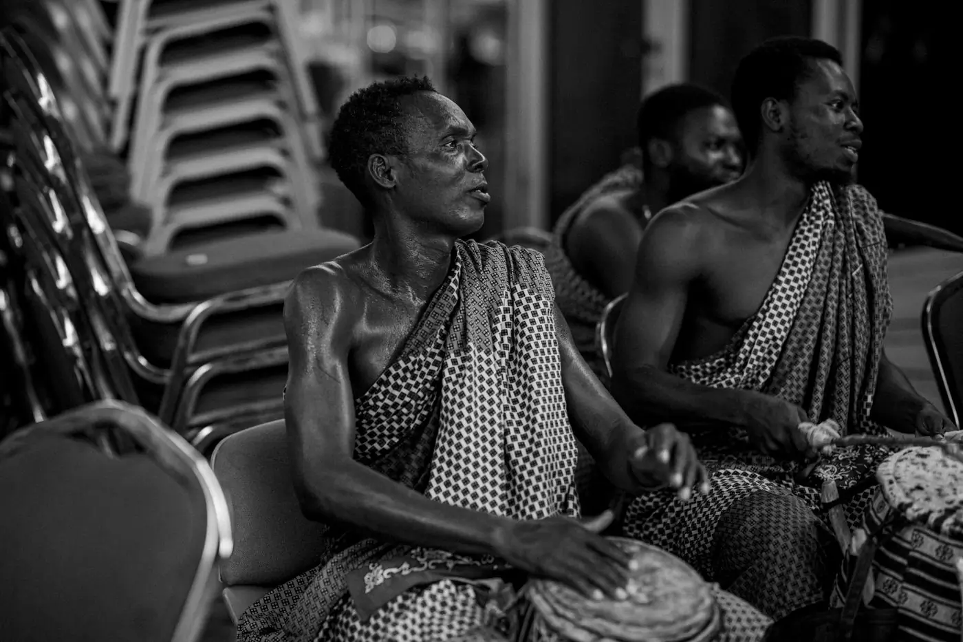 Drummers in traditional cloth playing at a cultural event in Accra