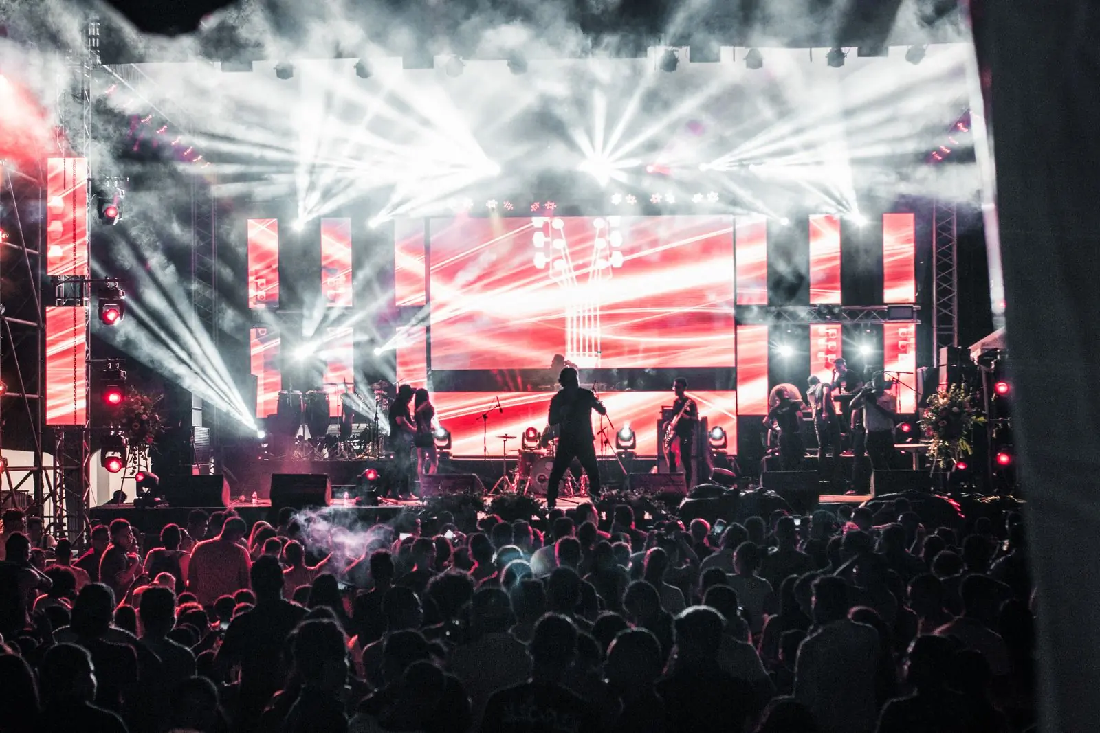 A large crowd in front of a lit stage