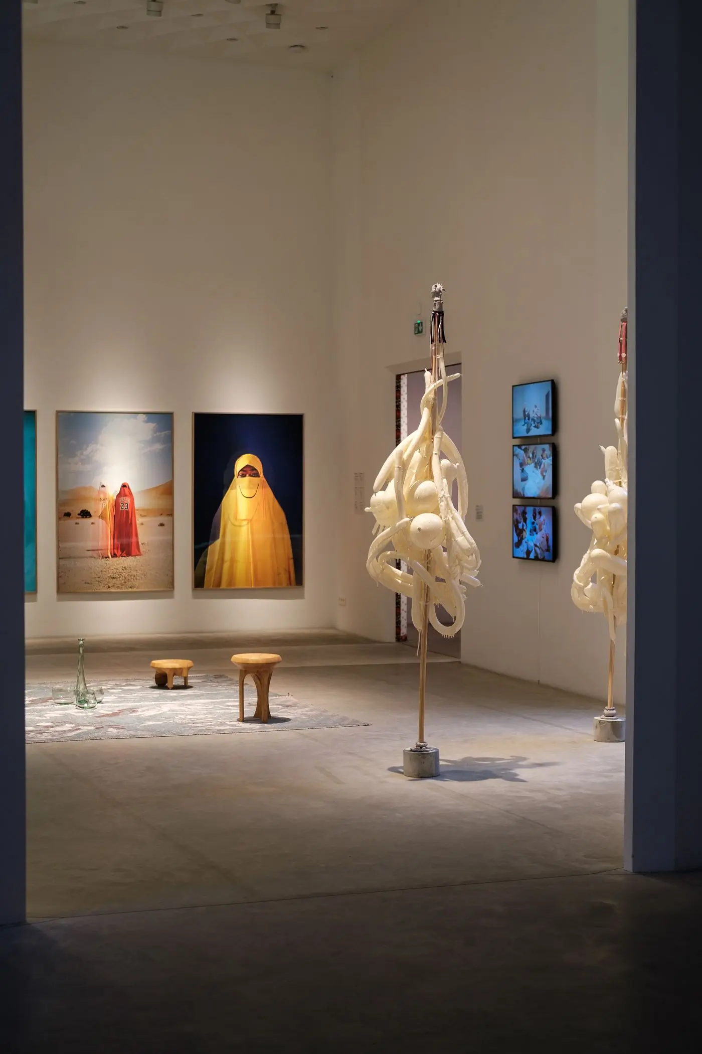 A gallery hung with large photographic prints and a sculpture
