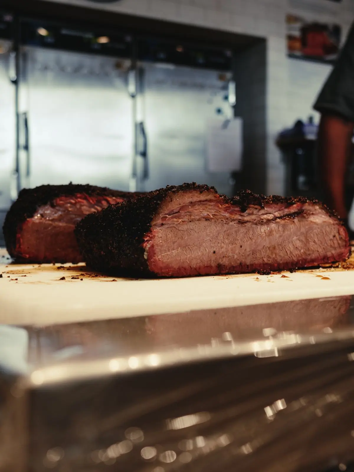 Sliced smoked brisket showing its smoke ring on a wooden board