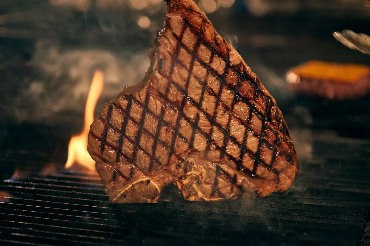 A thick bone-in ribeye with deep crosshatched grill marks
