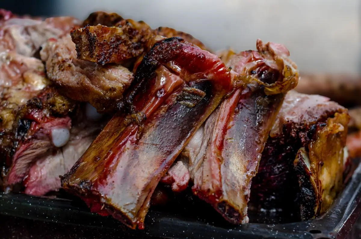 Glazed pork ribs resting under a low light
