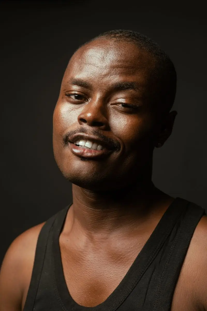 Yaw Mensah, a guest, photographed against a dark ground