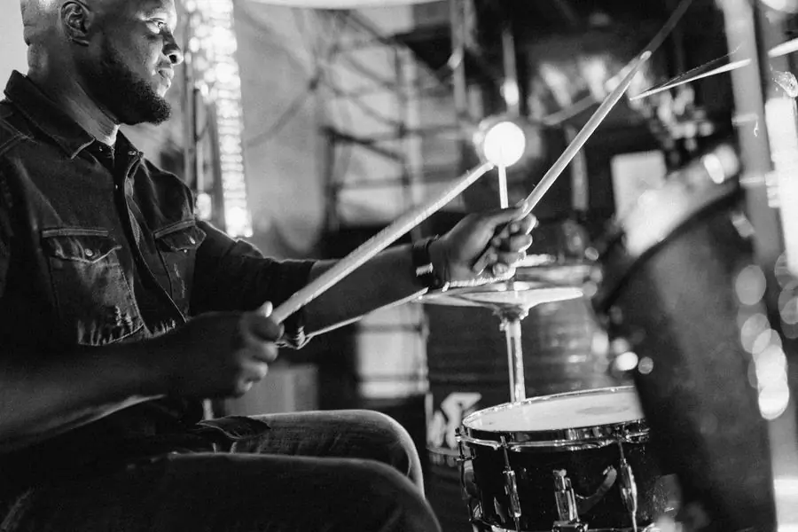 A drummer playing a kit, photographed in black and white