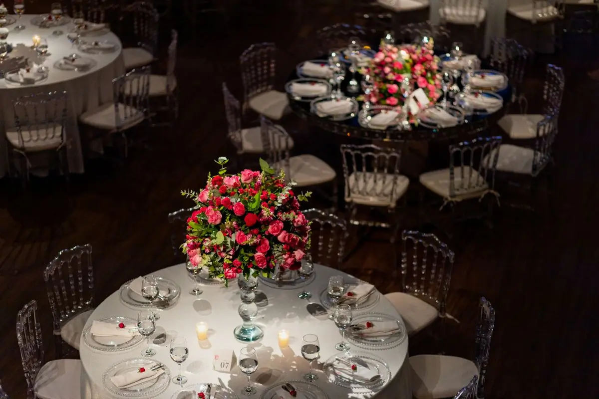 Round tables laid with floral centrepieces at a formal dinner
