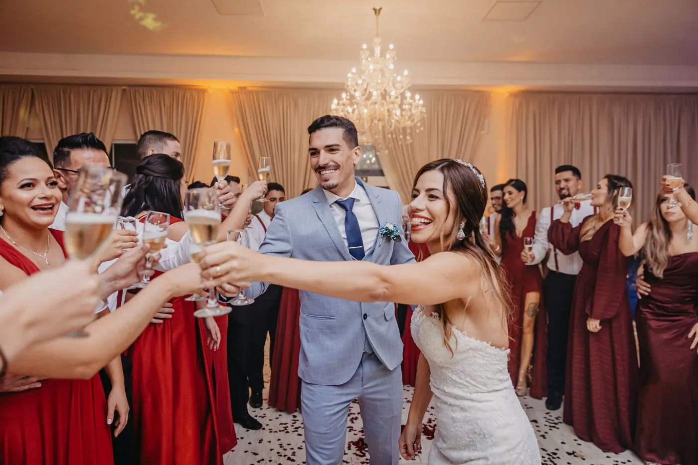 A couple and their guests raising glasses for a toast at a reception