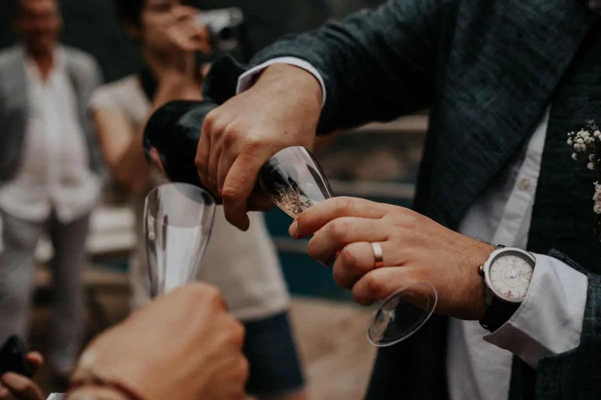 Wine being poured into a glass at an outdoor celebration