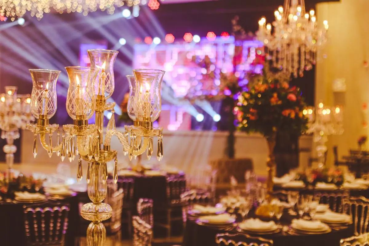 A ballroom laid for a gala dinner under crystal candelabra