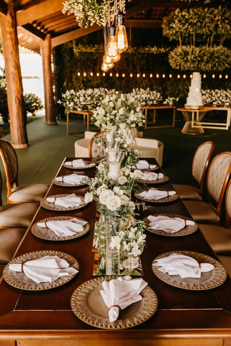 A long dining table dressed with tall floral centrepieces