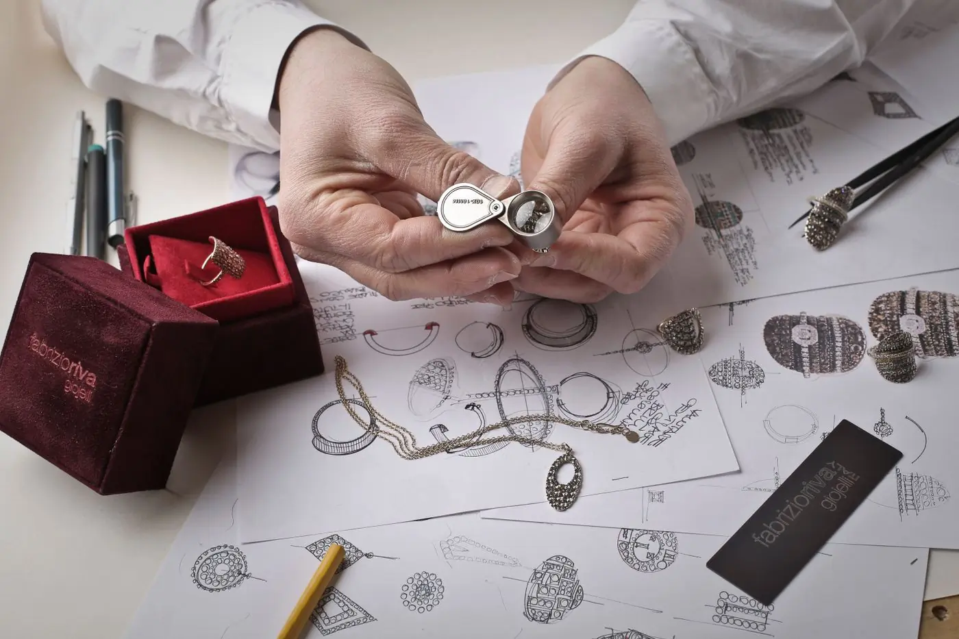 A Facet goldsmith's hands finishing a gold ring at the bench, files and polishing cloths within reach