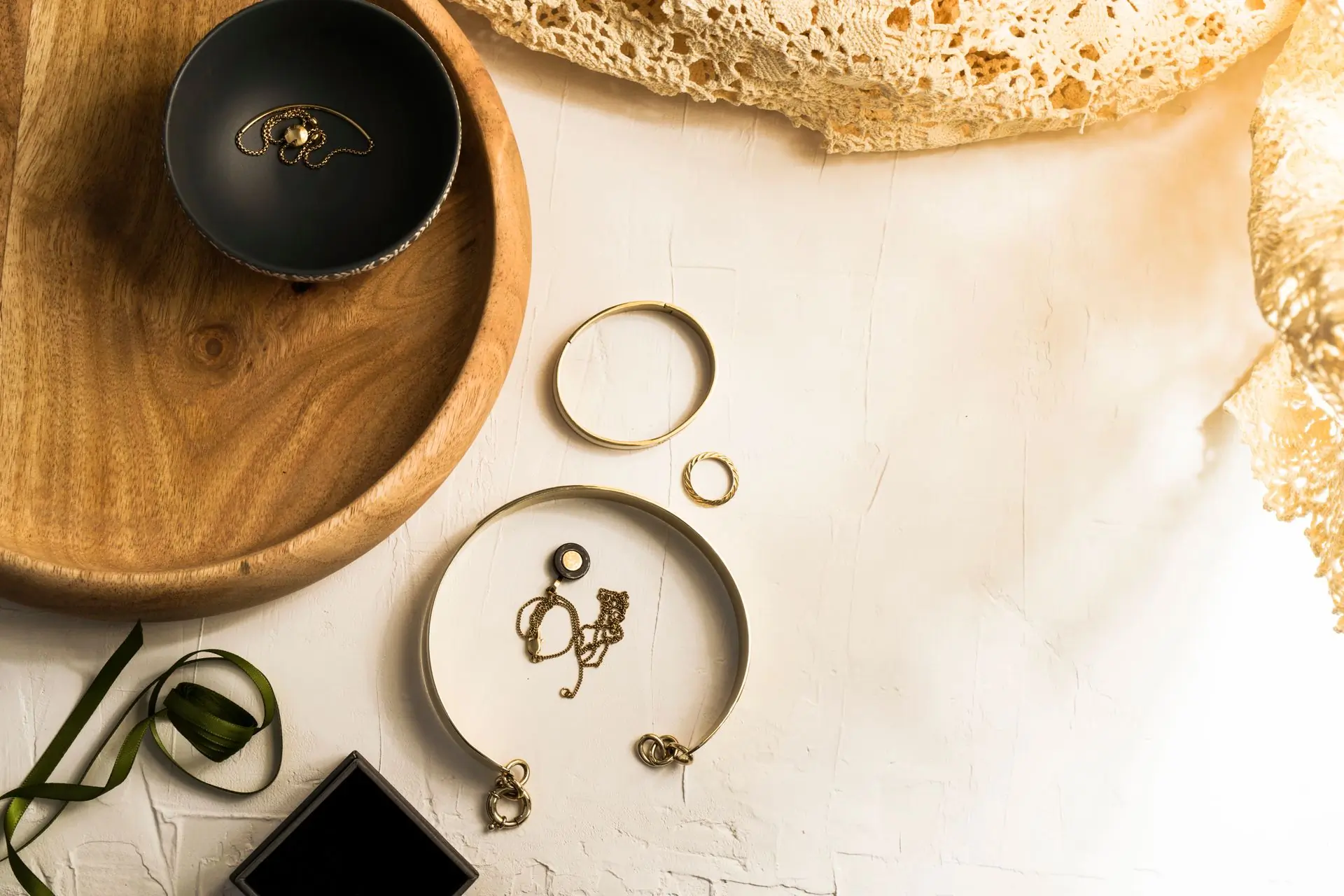 The Facet atelier in Accra, a goldsmith's bench under warm light with tools and gold pieces laid out midway through a setting