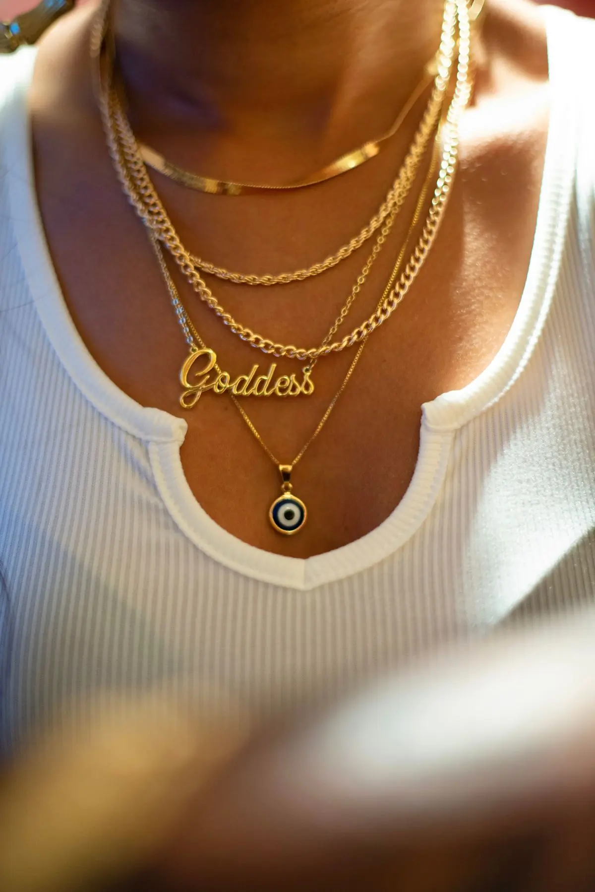 A layered gold necklace worn close against the skin