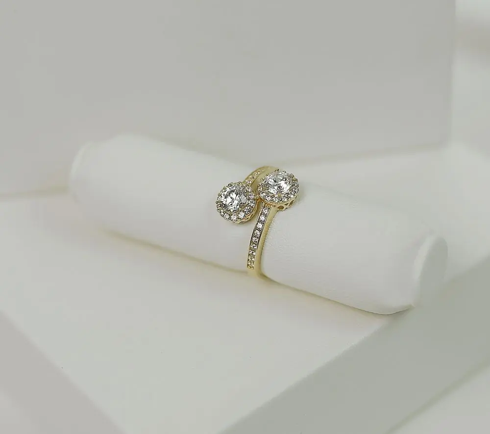 The Ama Solitaire displayed on a white leather roll, its twin halos of small diamonds catching the light