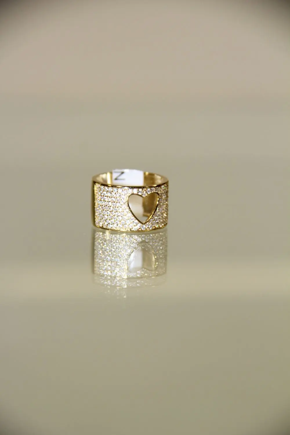 A rose gold ring set with a heart cut stone, on a white ground