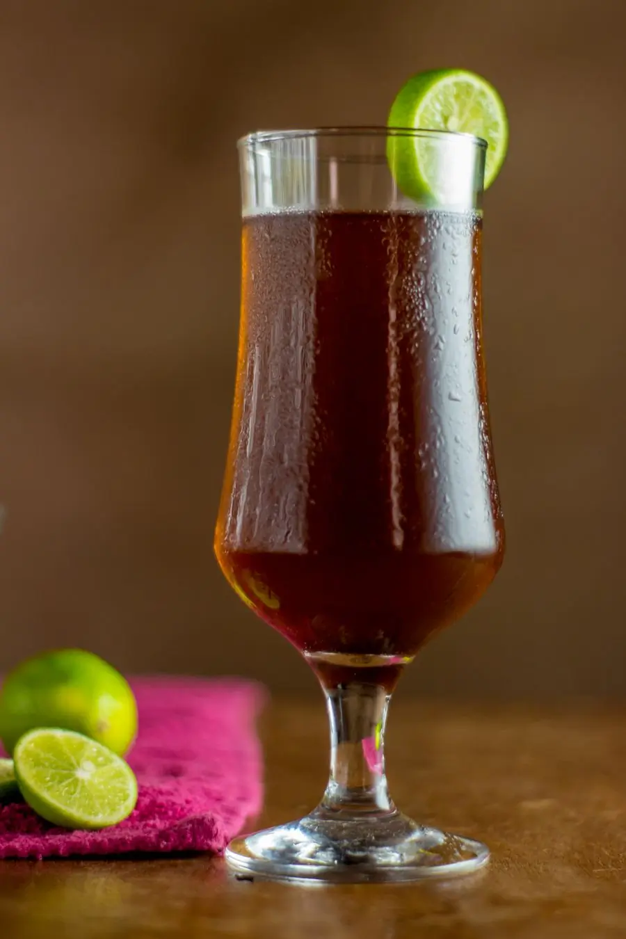 A tall glass of something dark over ice