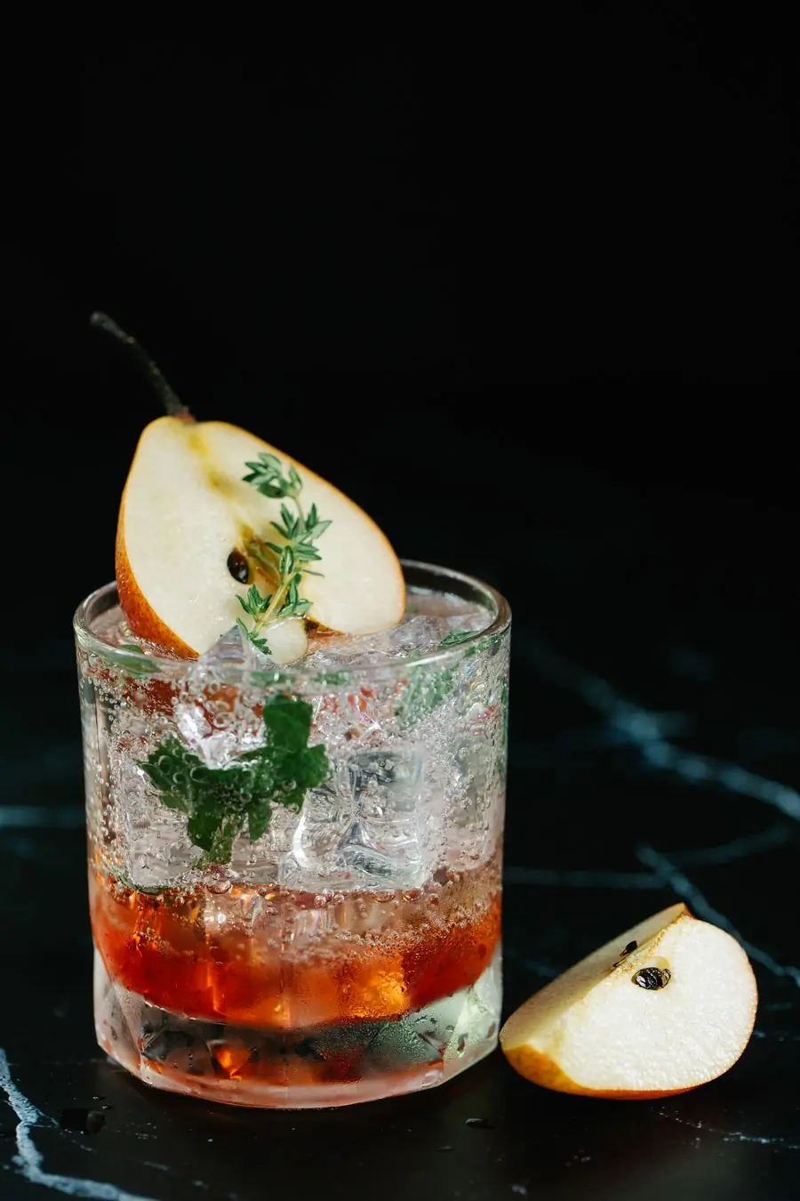 A pear and thyme highball on black marble