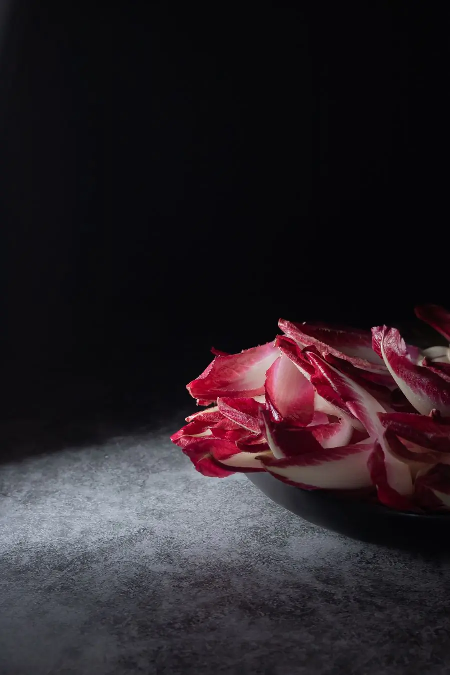 Red chicory leaves against a black ground