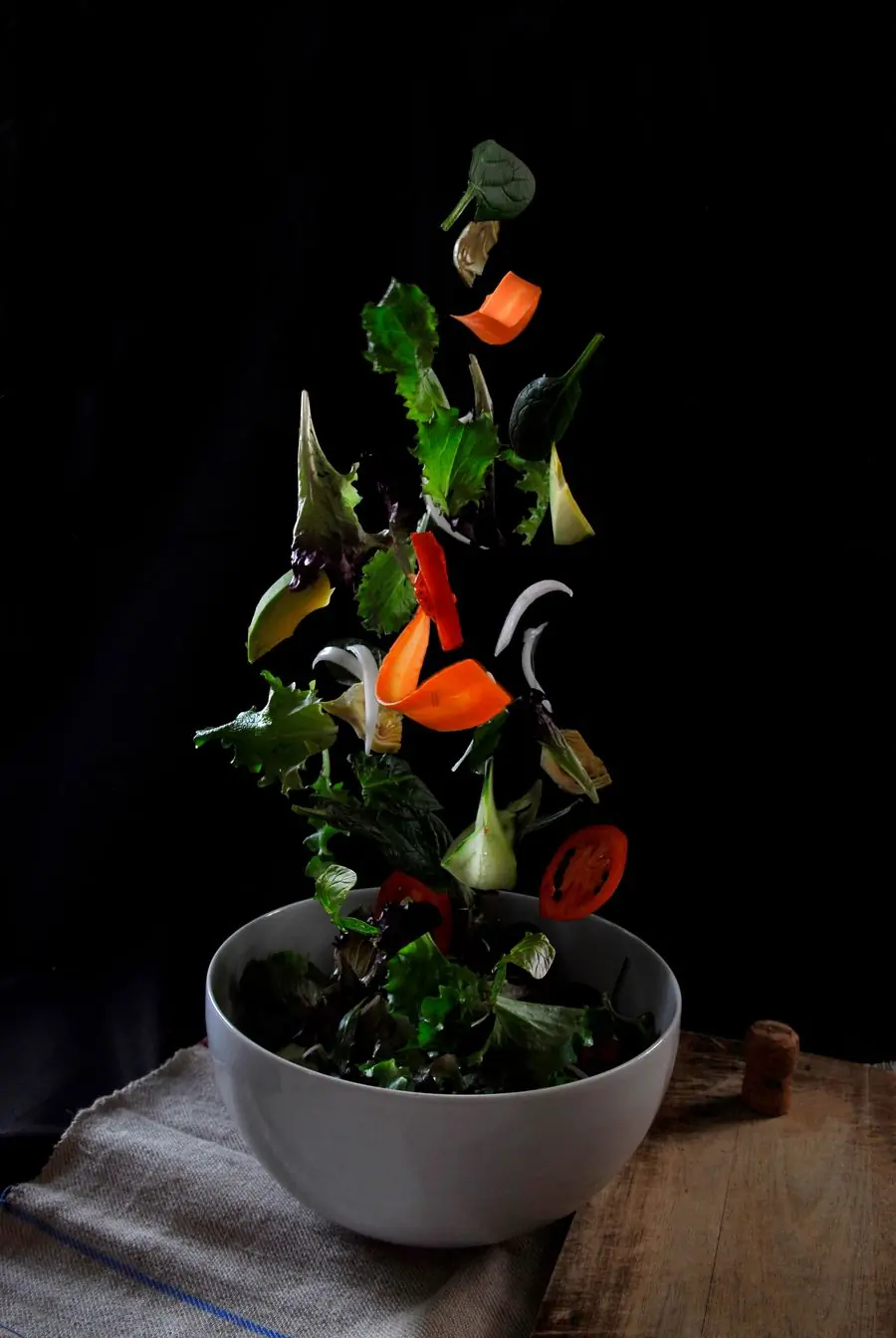 Vegetables falling into a bowl in mid air