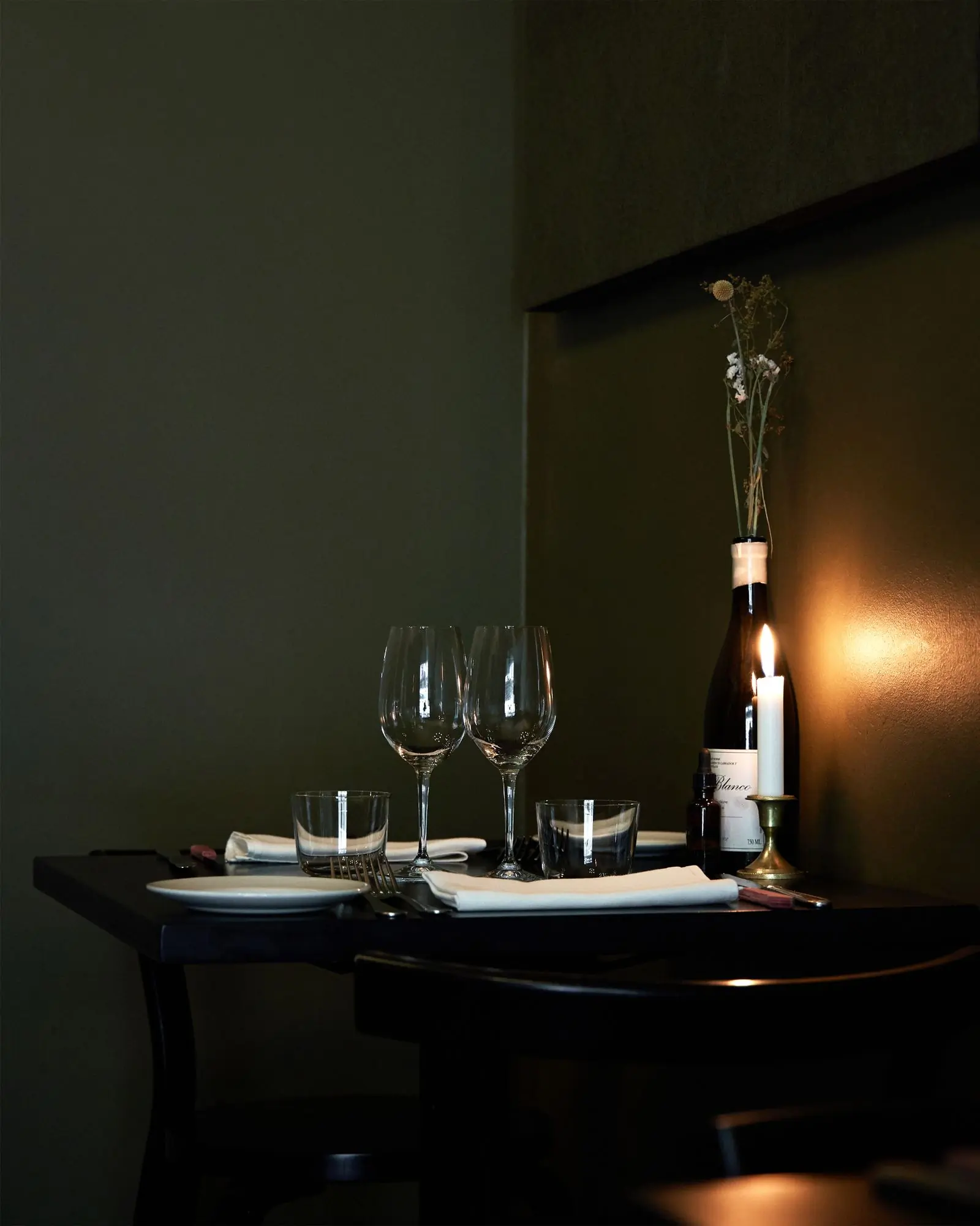 A table laid with wine glasses and a candle in the front room