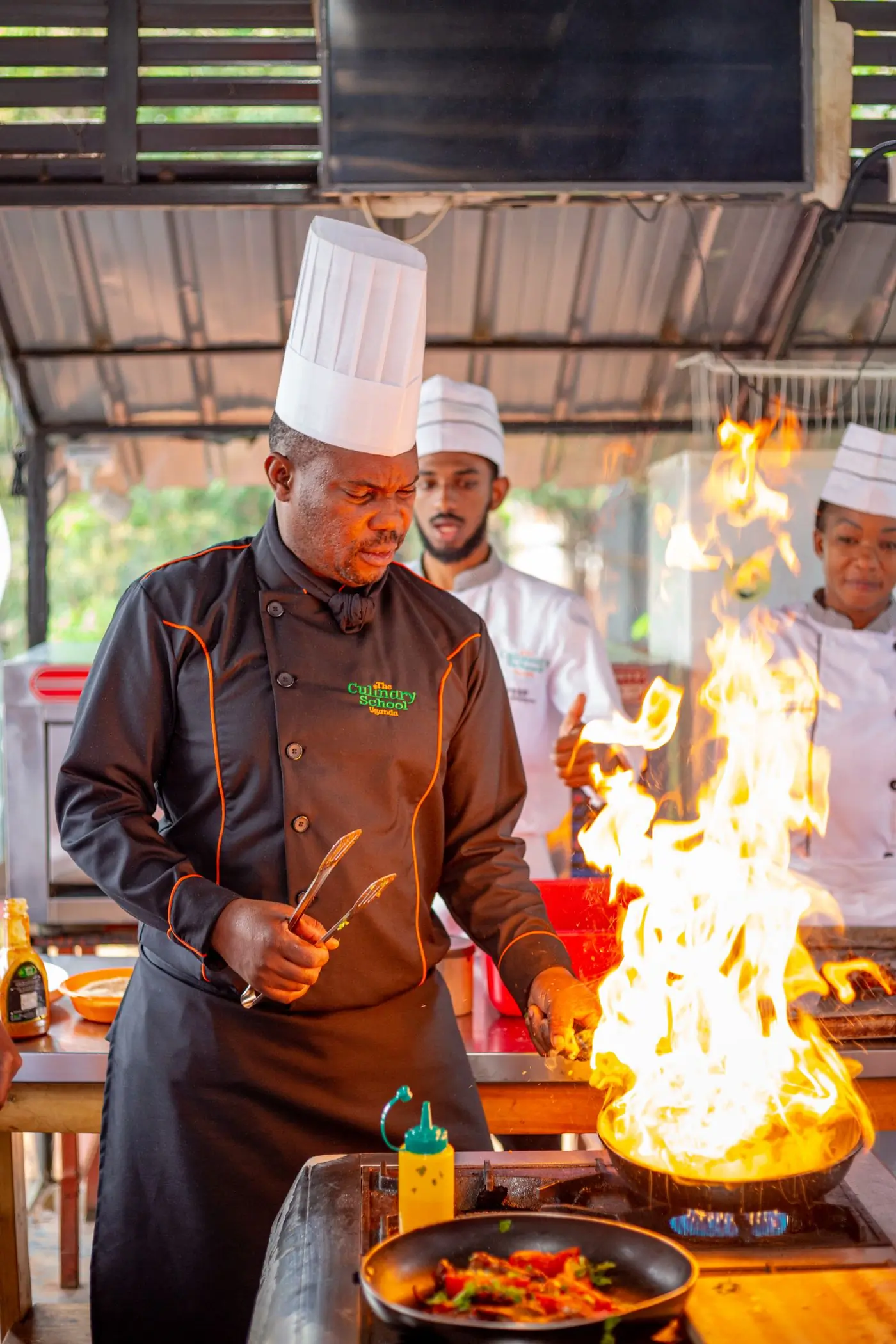 Three cooks working over open flames in the Feast kitchen
