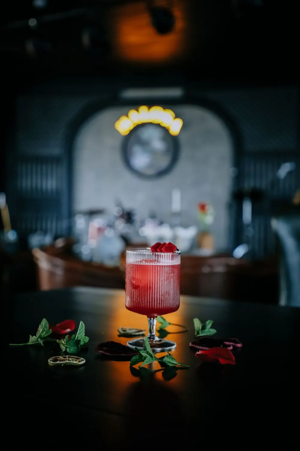 A red cocktail with mint on the bar counter
