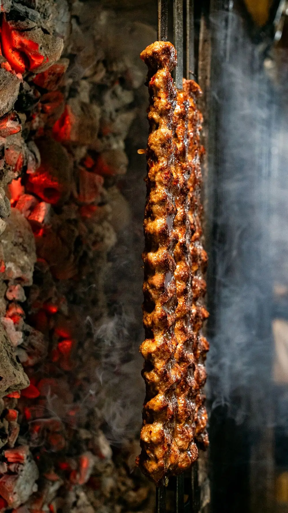 Meat skewers turning over open flames