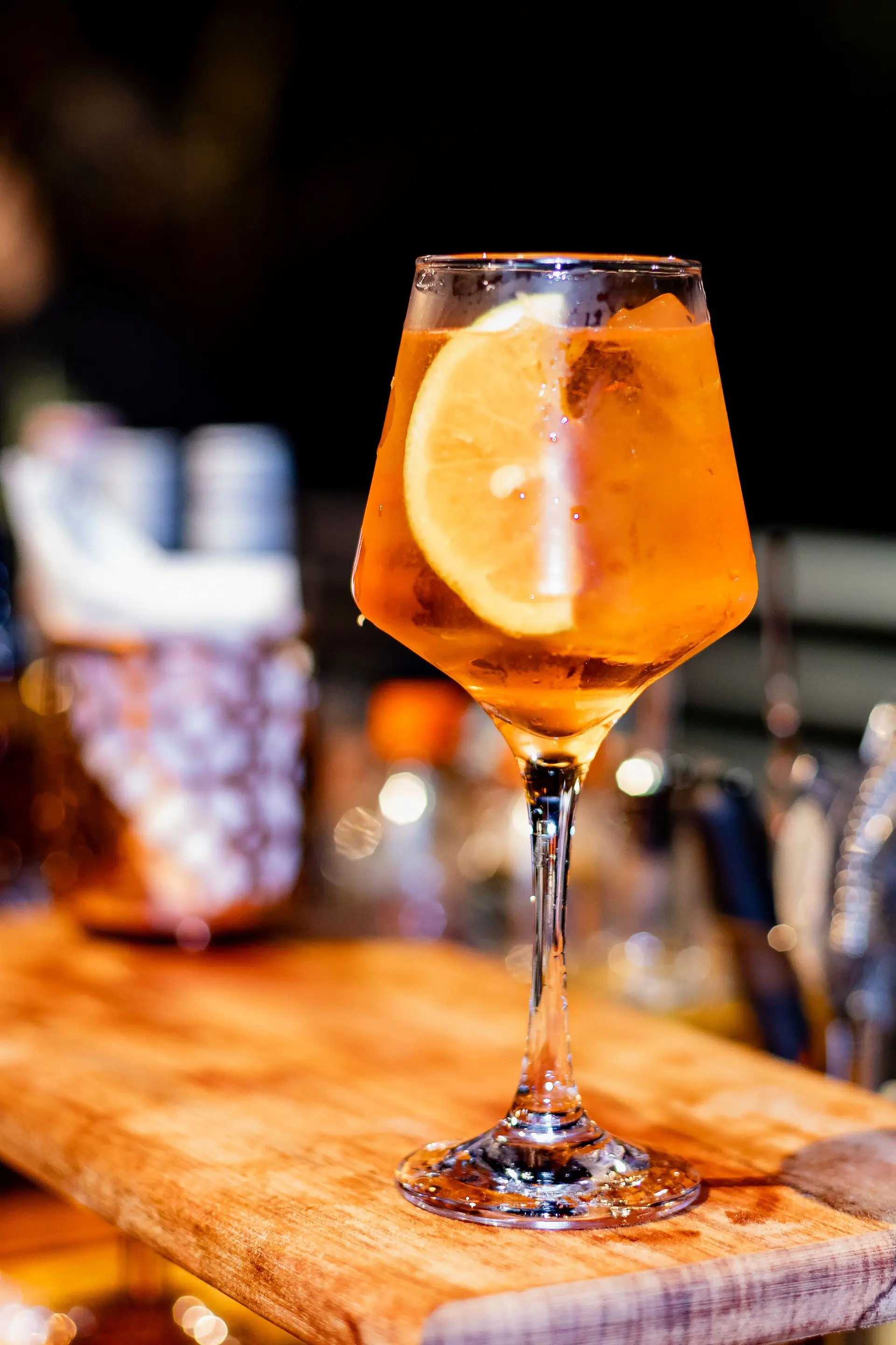An orange citrus spritz in a stemmed glass