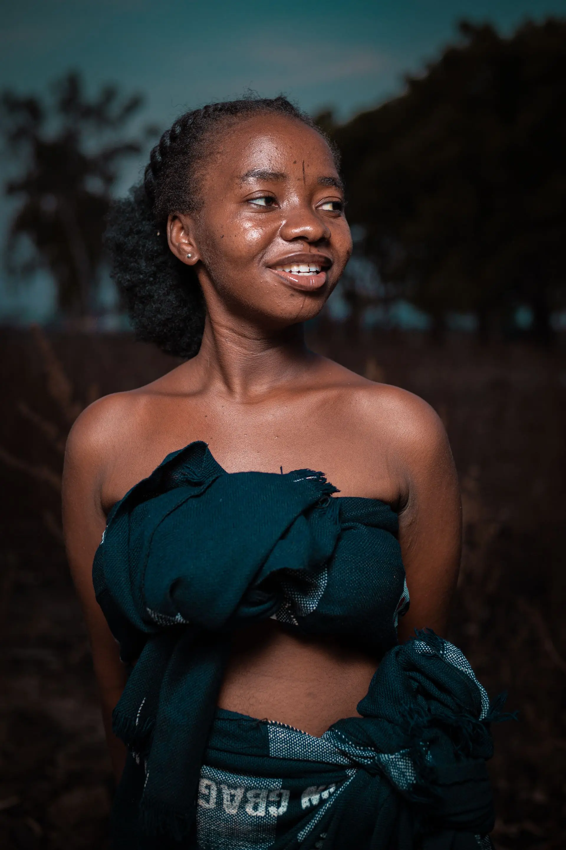 A woman with braids smiling at the camera