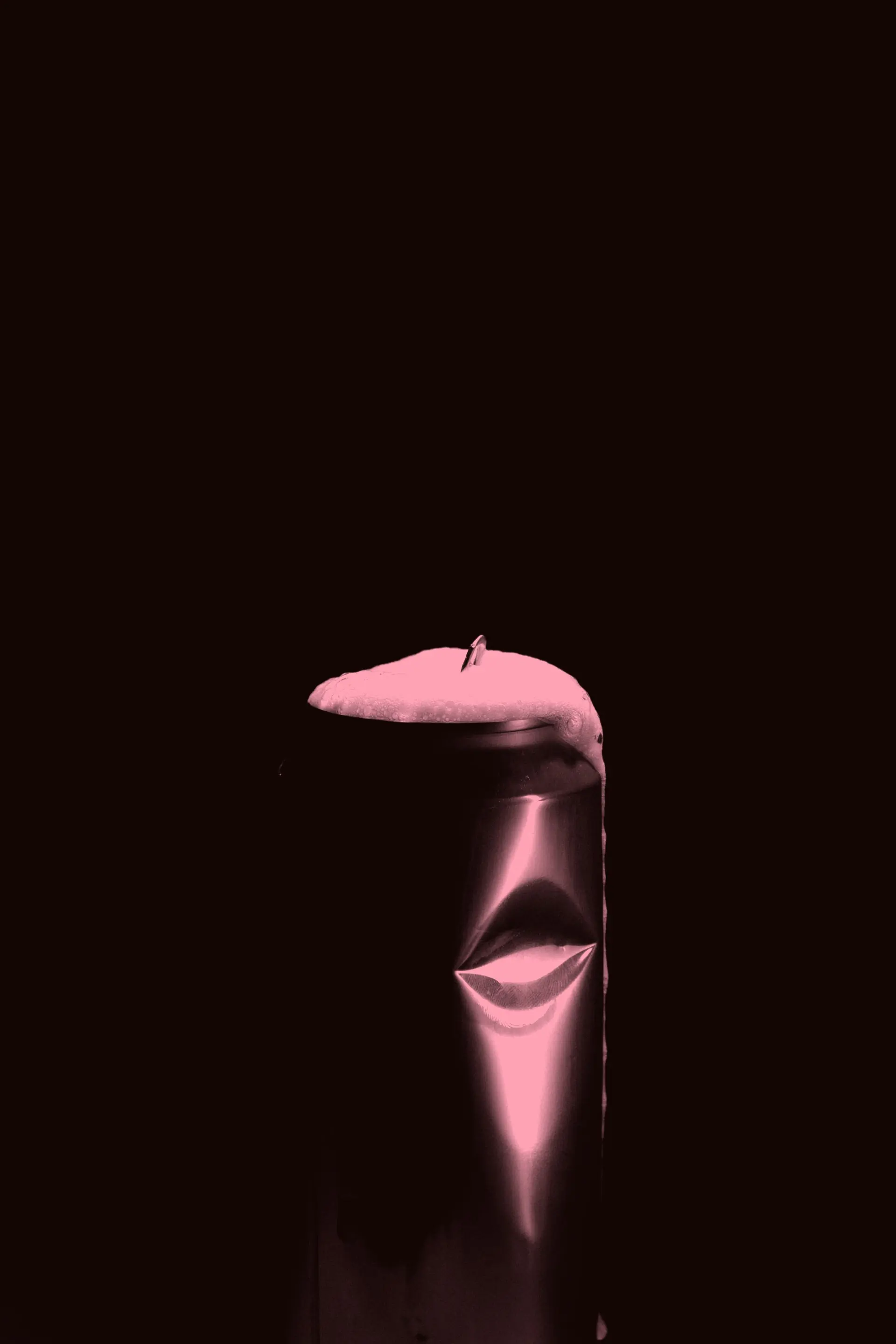 A can overflowing with foam against black, graded in the cream soda pink